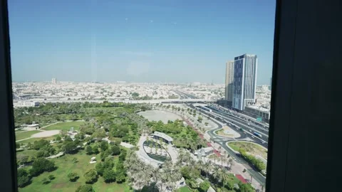 Panoramic view from moving glass elevator in Dubai Frame showcasing lush park Stock Footage 297434942