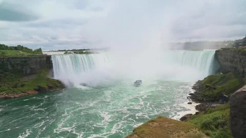 Panoramic view of Niagara Falls with boat cruising through mist-filled waters Video stock 294296173