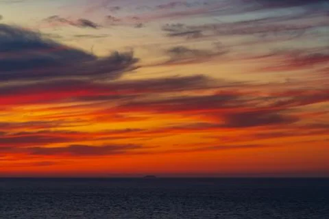 Panoramic view of the ocean sunset against the multi-colored stratus clouds Stock Photos