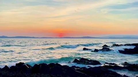 Panoramic view of ocean waves crashing on rocks during sunset at Van Chay Stock Footage 327913328