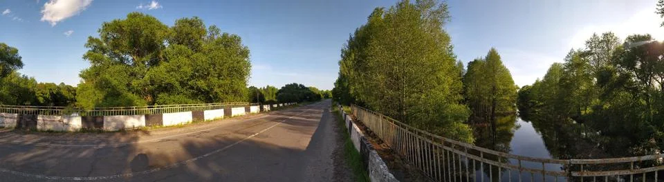 Panoramic view of old bridge over small river in countryside Stock Photos