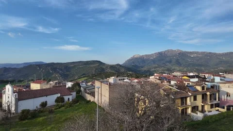 Panoramic View of Orgosolo and Mountains Beneath Moving Clouds Stock Footage 342003560