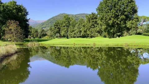 Panoramic View over a Golf Course with Lake and Mountain Stock Footage 264756199