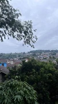 A panoramic view over a quiet village with rooftops and trees, framed by over Foto stock