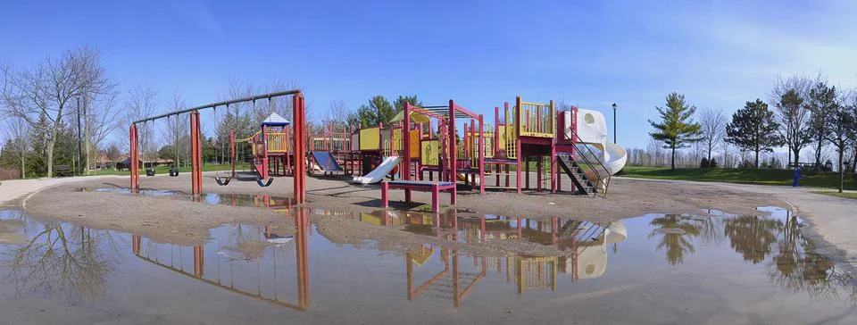 Panoramic view of the playground with reflection at the public park in spring Stock Photos