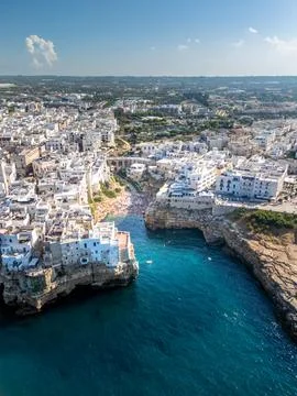 Panoramic view of Polignano a Mare town perched on limestone cliffs above the Stock Photos