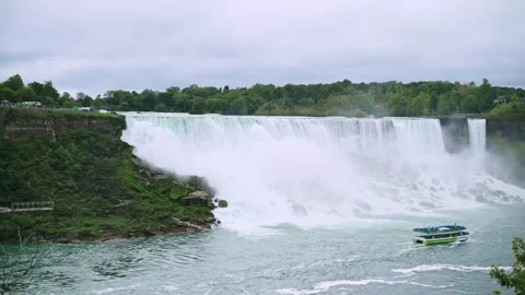 Panoramic view of powerful Niagara Falls with tour boat navigating near Stock Footage 292603389