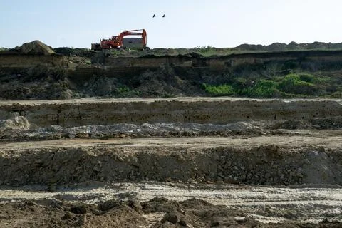 Panoramic view of the quarry, excavator working on top. Stock Photos