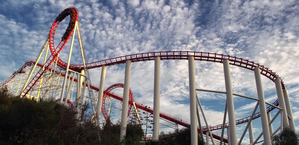 Panoramic view of red roller coaster track with beautiful cloudy sky Stock Photos
