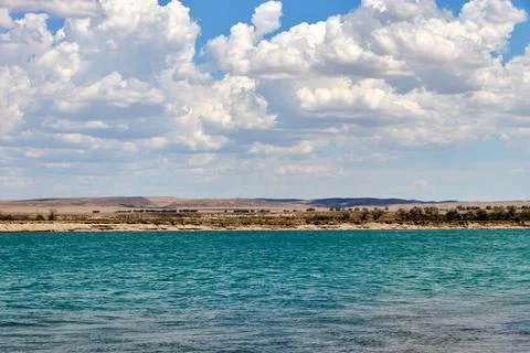 Panoramic view of the river with a calm current and cloudy sky Stock Photos
