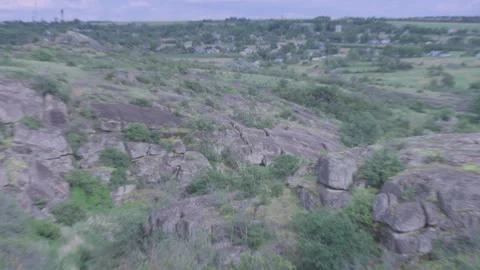 Panoramic view of a rocky canyon and green hills under a dramatic cloudy sky. 스톡 동영상 337471840