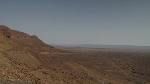 Panoramic view of rocky desert mountain cliff and vast arid plain in Morocco Stock Footage 335959495