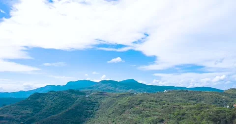 Panoramic view of rolling green mountains under a bright blue sky with clouds Video stock 342090886