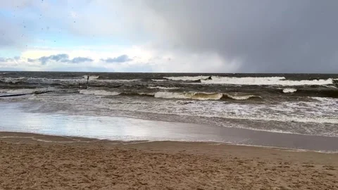 A panoramic View of Sandy Beach and Rolling Waves on a winter snowy day Stock Footage 297354966