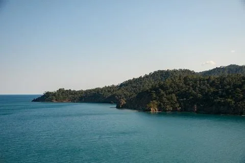 Panoramic view of sea on background of mountain ranges with green trees and blue 스톡 사진