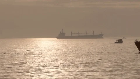 Panoramic view of the sea lit by the sun, swims a small ship leaving a trail on Stock Footage 109599837
