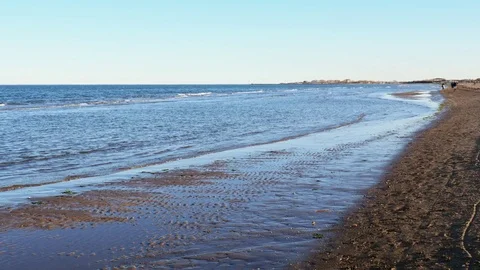 Panoramic view sea surf on a sandy coast  and walking people on coastline Stock Footage 82857859