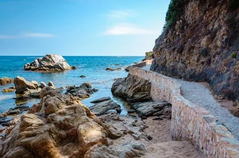 Panoramic view of seashore with rock cliff and a road Stock Photos