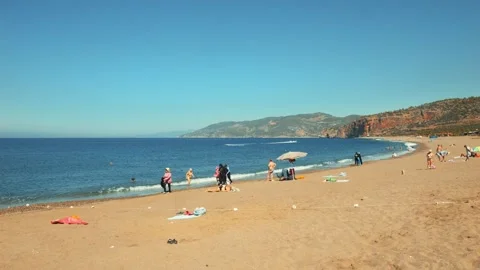 Panoramic View of Selinus Beach in Gazipasa, Turkey, with People Sunbathing and Stock Footage 294743596