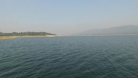Panoramic view of a serene lake surrounded by misty green hills Stock-Footage 335270730