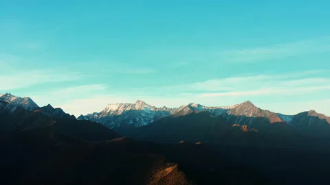 Panoramic view of sharp snow-capped mountains. Blue sky and mountains silhouette Stock Footage 144095444