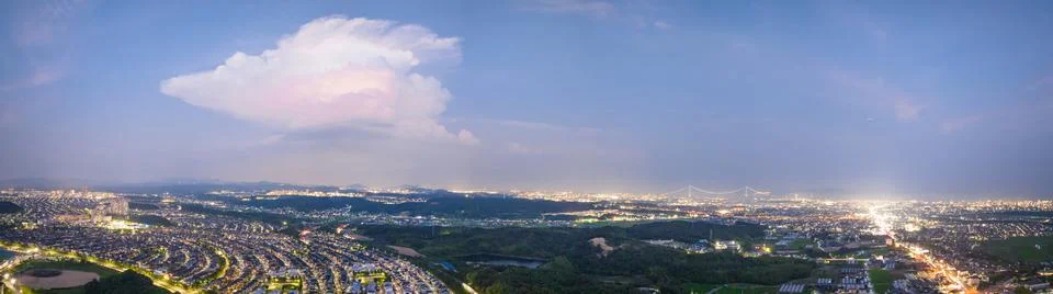 Panoramic view of single cloud over sprawling cityscape at night Stock Photos