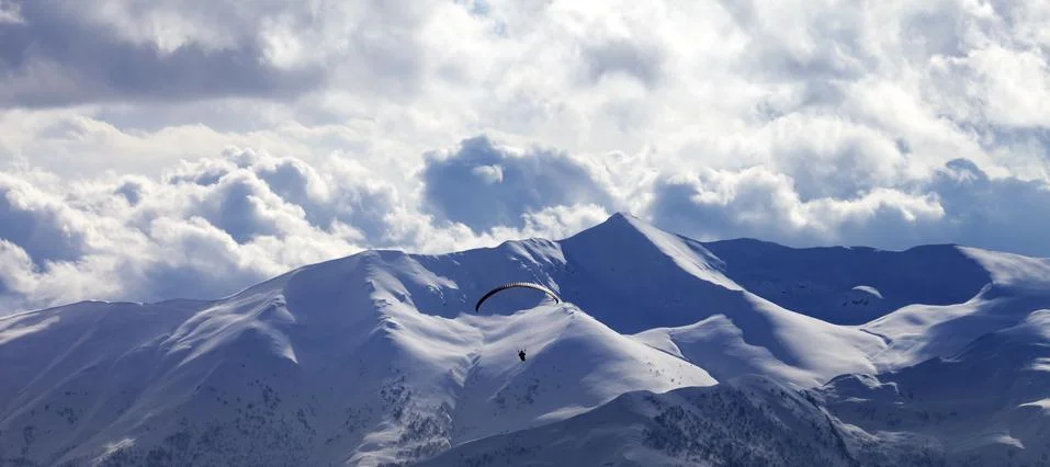 Panoramic view on skydiver at evening cloudy mountains Fotos de archivo