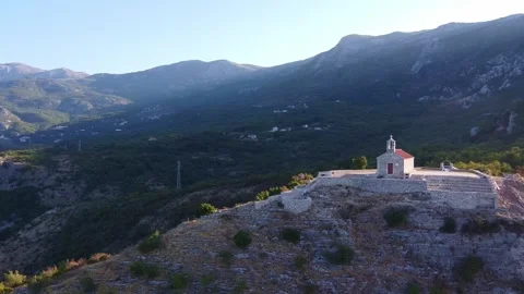 Panoramic view of small white church on rocky outcrop in mountains 스톡 동영상 342766351