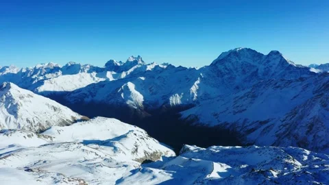 Panoramic view of the snow capped Greater Caucasus mountain range in Russia on a Stock Footage 320856164