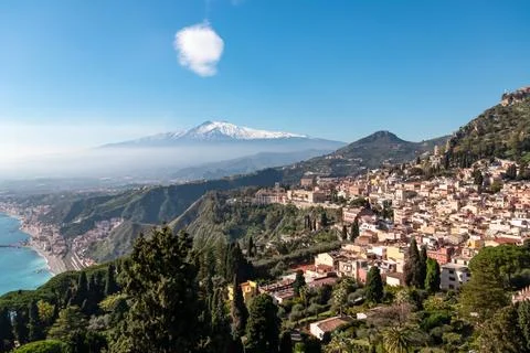 Panoramic view on snow capped Mount Etna volcano and Mediterranean coastlin.. Stock Photos
