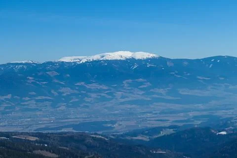 Panoramic view on the snow capped mountains of Koralpe seen from the mounta.. Stock Photos