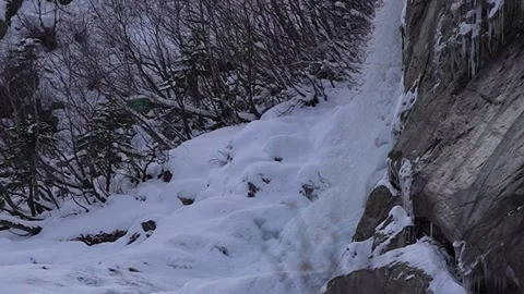 Panoramic view of a snow-covered waterfall in the winter forest Stock Footage 310231669