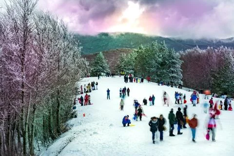 Panoramic view of a Snowed Mountain with Colored Trees and Blurred People 库存照片