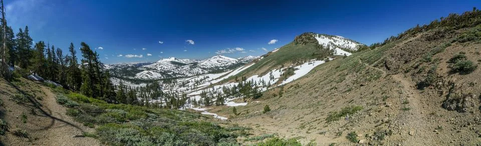 A panoramic view of a snowy mountain range with a clear blue sky Foto stock