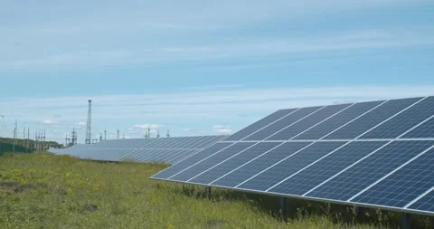 Panoramic view on the solar power station, blue sky and green grass, 4k Stock Footage 134003082