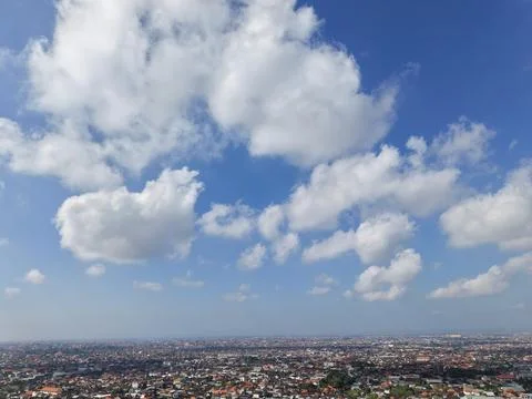 Panoramic View of Sprawling Cityscape Under a Blue Sky with Fluffy White Clouds Stock Photos