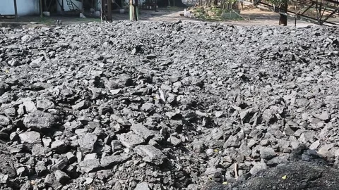 A panoramic view of stacked charcoal heaps isolated at the factory yard Vídeo Stock 245091040