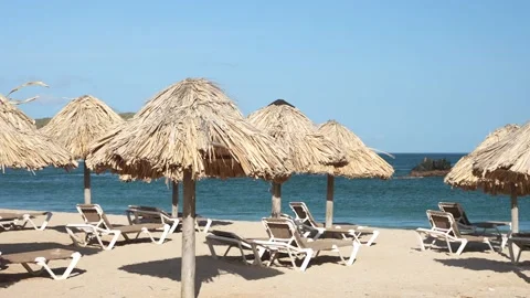 Panoramic view of straw umbrellas and empty sun loungers on the beach with no Stock Footage 226195679