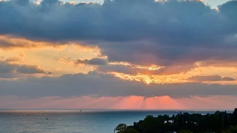 Panoramic view of sun rays from clouds at sunset Stock Photos