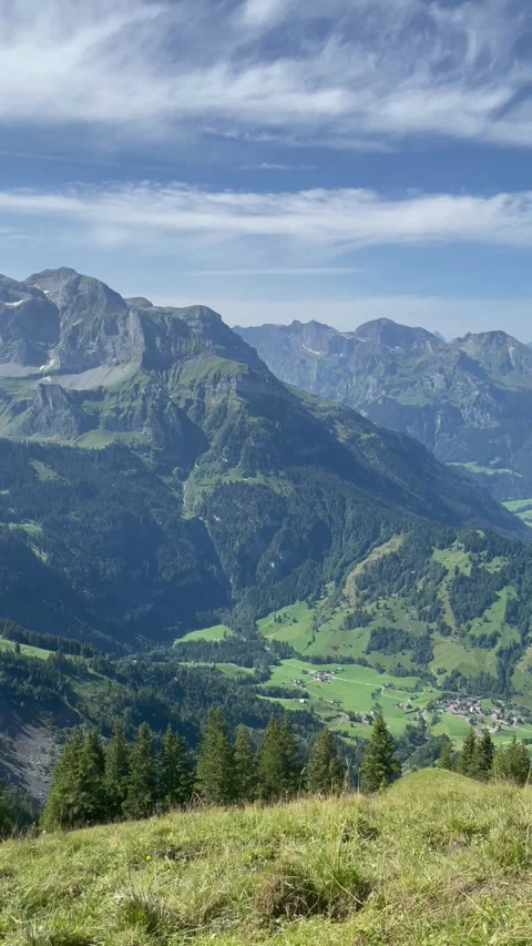 Panoramic view of the Swiss Alps with green mountain ridge and blue sky Video stock 341436778