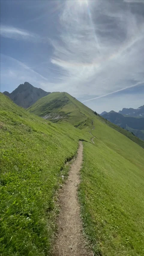 Panoramic view of the Swiss Alps with green mountain ridge and blue sky Stockbeeldmateriaal 341436779