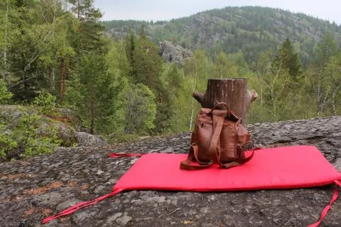 Panoramic view. Things traveler - a backpack and yoga mat on top of the mountain Stock-Fotos