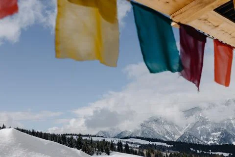Panoramic view through colorful flags on snowy mountains Stock Photos