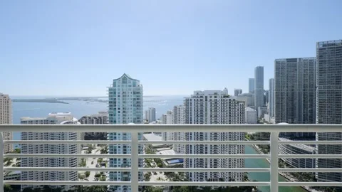 Panoramic view through high floor apartment balcony of city with ocean aside Video stock 258403307