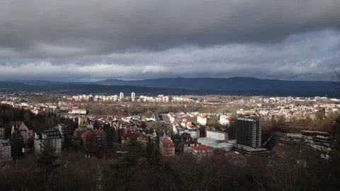 A panoramic view of a town nestled between hills and mountains under a dramatic  Stock Footage 300540721