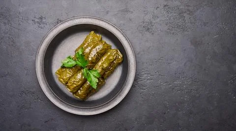 Panoramic view traditional Middle Eastern dish dolma, stuffed grape leaves and Stock Photos