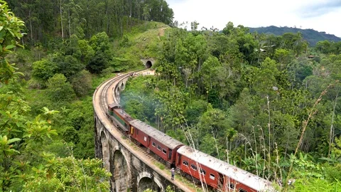 Panoramic view of the train passing by the Nine Arches bridge of Ella, Sri Lanka Stock Footage 89495837