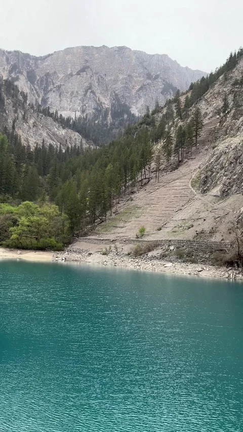 Panoramic View of Turquoise Lake Amidst Rocky Mountains in Jiuzhaigou, Sichuan 動画素材 337007801