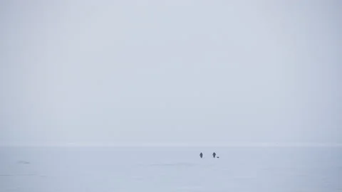 Panoramic view two people walking across the snow-covered Baltic sea 스톡 동영상 171309544