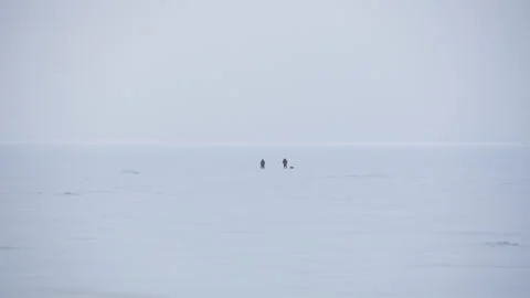 Panoramic view two people walking across the snow-covered Baltic sea 스톡 동영상 171310435